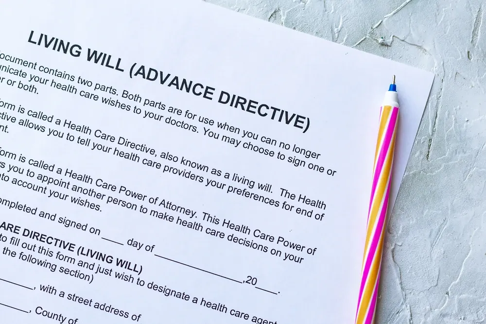 Close-up of a living will (advance directive) document with a colorful pen on a textured surface.